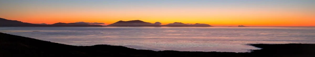 Ein malerischer Sonnenuntergang an der schroffen Küste des West Point Island.