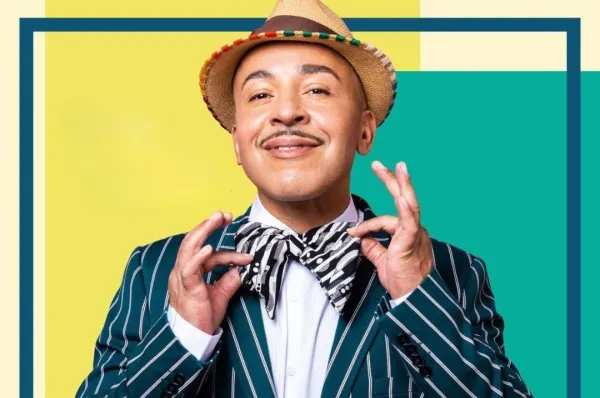 4 Nächte - Mein Schiff Millennium Cruise 2027 Lou Bega gehört zu den Stargästen der Millennium Cruise 2027. Auf dem Bild ist der Künstler vor einem bunten Hintergrund aus gelb, beige, türkis, blau und orange zu sehen.