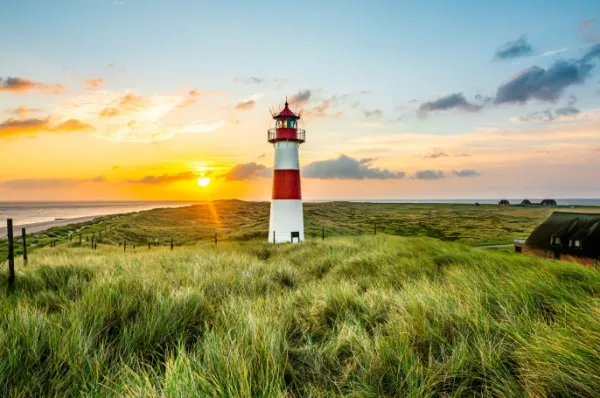 Sylt Rot-weißer Leuchtturm in den Dünen bei Sonnenuntergang auf Sylt.