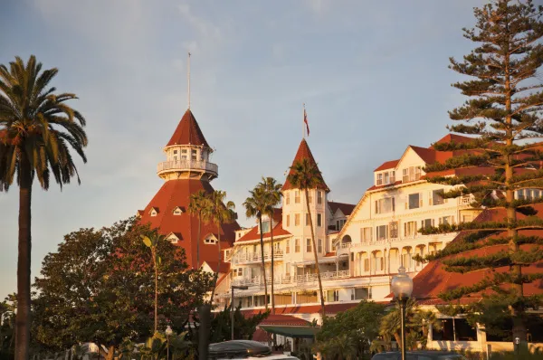 Ein altes Gebäude bei San Diego Ein historisches Resort bei San Diego, gekennzeichnet durch alte spanische Architektur bei Tag mit Palmen im Vordergrund.