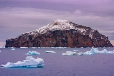 Insel in der Antarktis in einem Meer von Eisbergen.
