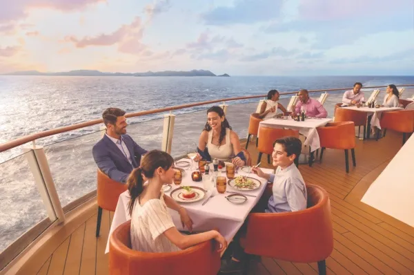 Dining an Bord von Norwegian Cruise Line Außenbereich eines Bordrestaurants von Norwegian Cruise Line mit mehreren, vollbesetzten Tischen.