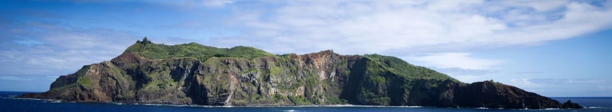 Grün bewachsene Steilküste der Pitcairn-Insel im Südpazifik