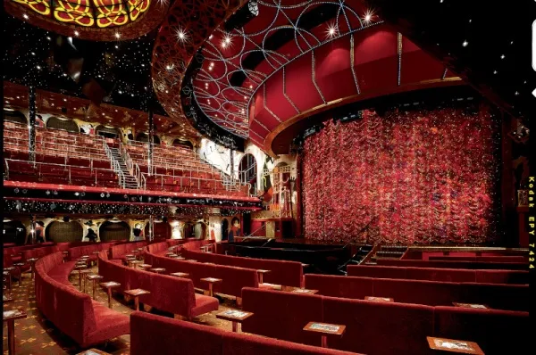 Theater mit roten Sitzen und roter Leinwand.