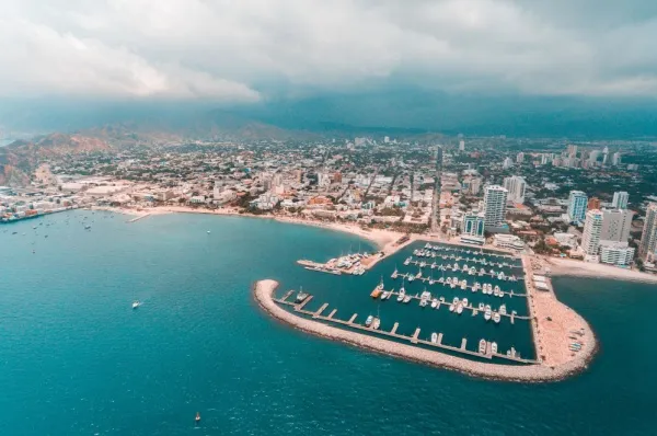 Luftbild des Hafens von Santa Marta mit dem Yachthafen und den Häusern der Stadt im Hintergrund.