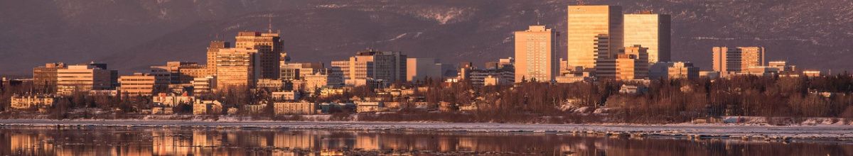 Die Stadt Anchorage vom Wasser aus fotografiert bei Sonnenuntergang.