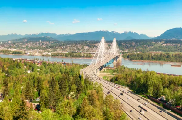 Blick auf Vancouver mit der markanten Capilano Suspension Bridge im Vordergrund bei Tag.