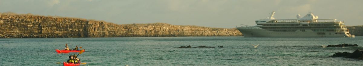 Zwei Kajaks fahren über das Meer, im Hintergrund die Silver Origin.