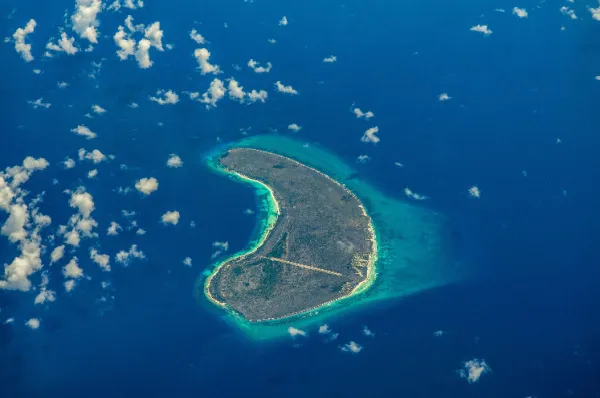 Das Aldabra-Atoll Luftaufnahme des cashewförmigen Atolls bei Tag umgeben vom Indischen Ozean.