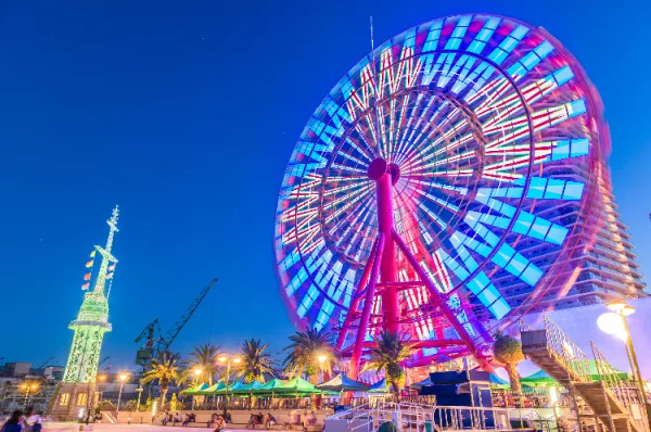 Ein beleuchtetes Riesenrad im Kobe Harborland am Abend.