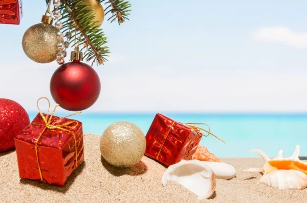 Weihnachtsgeschenke liegen an einem weißen Sandstrand.