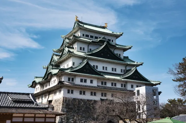 Die Burg von Nagoya Die mehrstöckige und klassisch japanische Burg von Nagoya bei Tag.