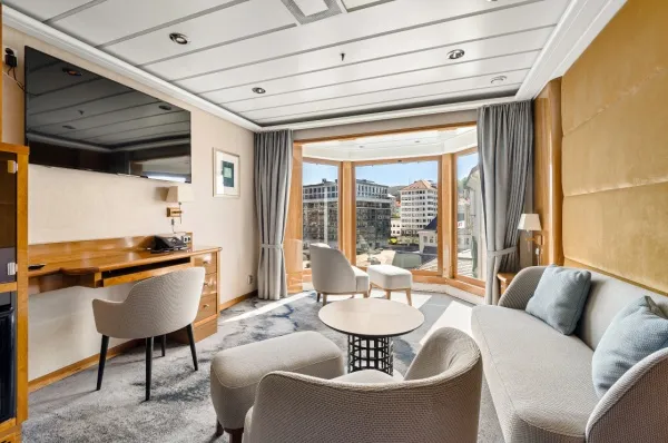 Expedition Suite MG Expeditions Suite an Bord von Hurtigruten Expeditions mit hellem, modernen Design und verschiedenen Sitzgelegenheiten.