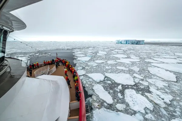 MS Roald Amundsen Bug der MS Roal Amundsen, auf denen Menschen das umgebende Eis betrachten.