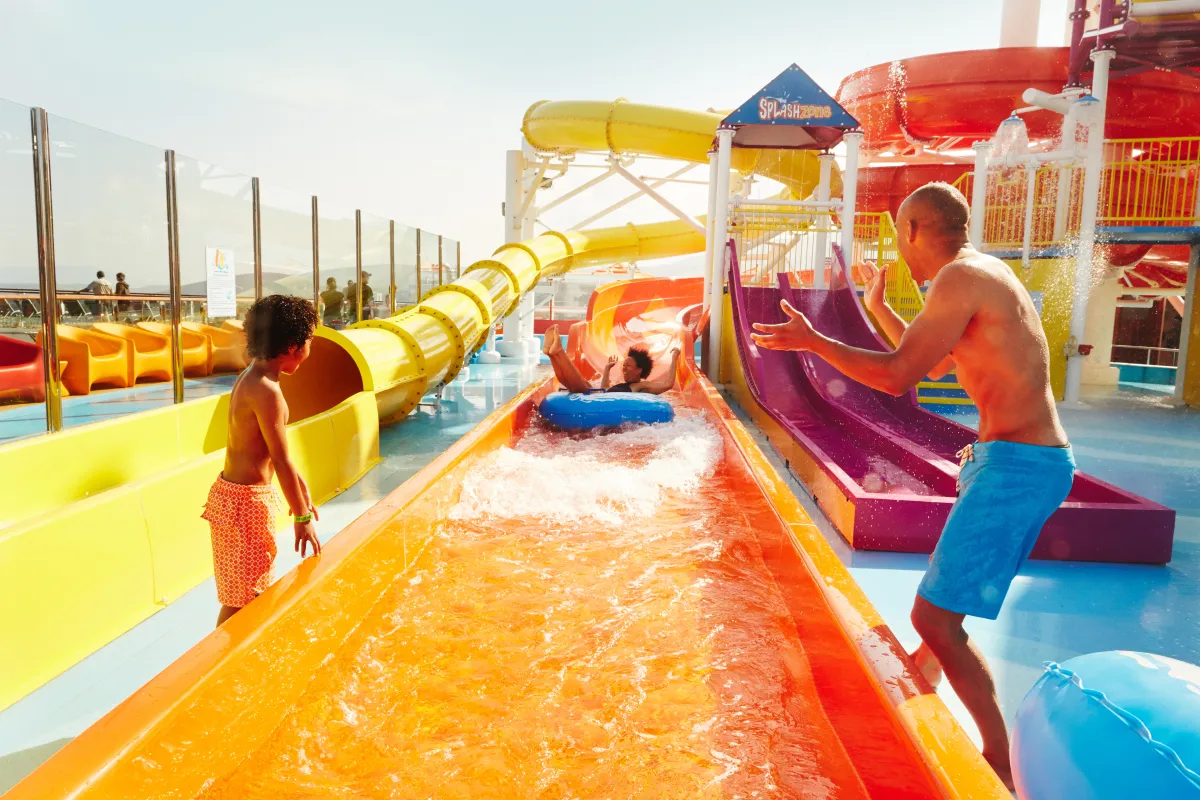 Bunte Wasserrutschen mit spielenden Kindern an Bord der Carnival Valor.