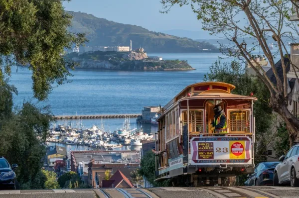 Historisches Cable Car fährt über hügelige Straßen in San Francisco.
