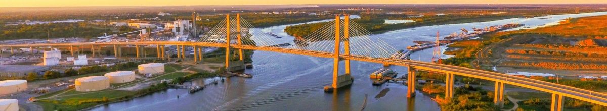Eine Brücke führt über einen Fluss bei Sonnenuntergang.