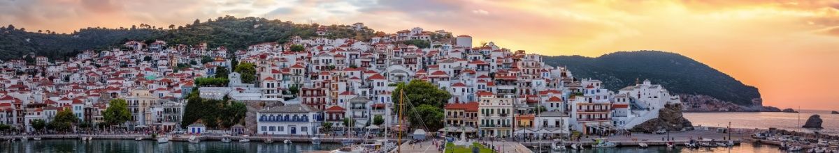 Skopleos Stadt mit den weißen Häusern auf einem Berg bei Sonnenuntergang.