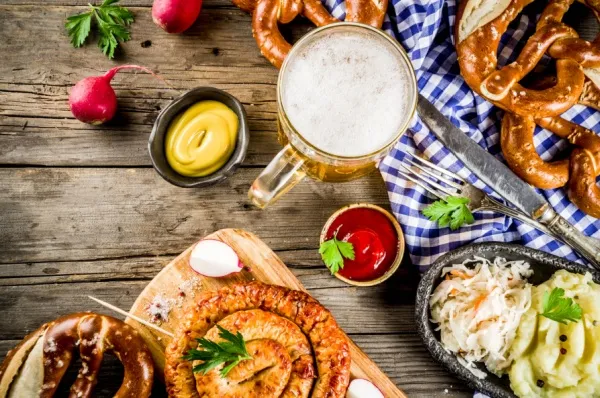 Der Tisch ist reich gedeckt: Bier, Brezn, Schweinshaxe, Wurstsalat und Obazda.