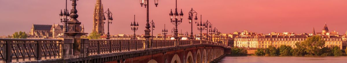 Eine rustikale Brücke über dem Fluss Garonne innerhalb von Bordeaux bei Abendröte.
