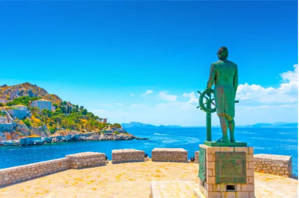 Die Statue eines Kapitäns auf Hydra mit Blick auf den Hafen, bei Tag.