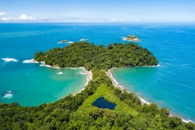 Zwei grüne Inseln miteinander verbunden im türkisblauen Meer.