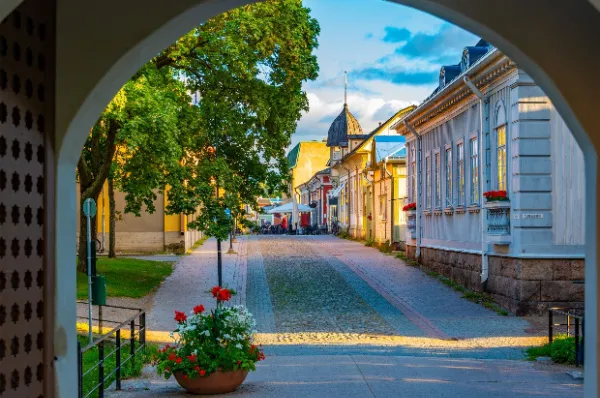 Ausschnitt der Innenstadt von Rauma unter einem Torbogen heraus fotografiert bei Sonnenschein.