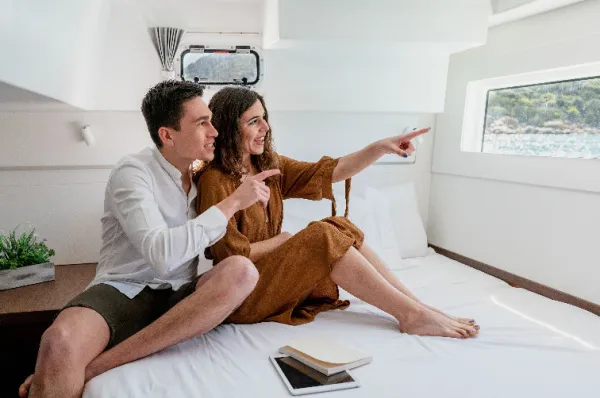 Ein Paar, das mit den Fingern auf das Fenster Ihrer Kabine zeigt.