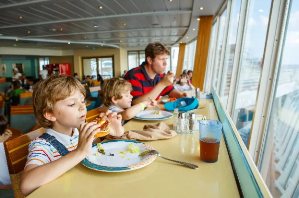 Ein Vater, der mit seinen Kindern frühstückt auf einem Kreuzfahrtschiff.