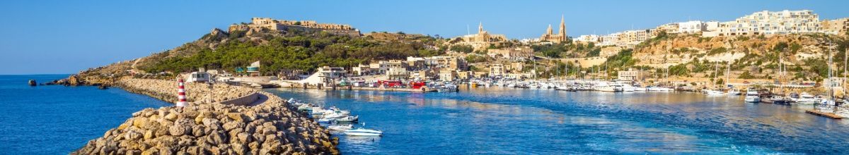Der Kreuzfahrthafen von Mgarr auf Gozo mit Leuchtturm im Vordergrund.