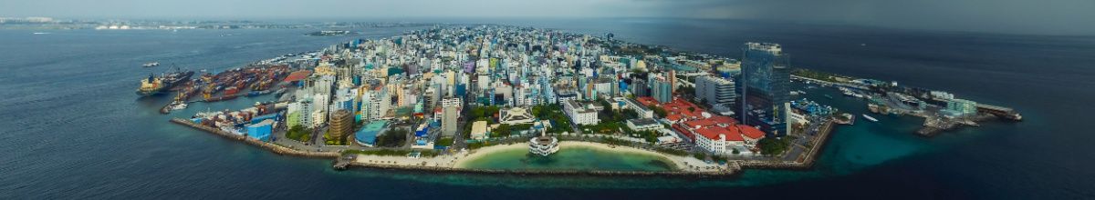 Die Skyline von Malé mit Hochhäusern und modernen Gebäuden am Meer.