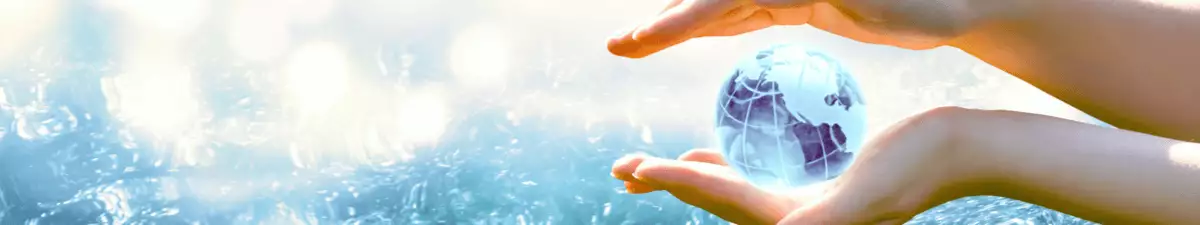 Zwei Hände halten eine Weltkugel über Wasser: Symbol für Umweltschutz bei Kreuzfahrten
