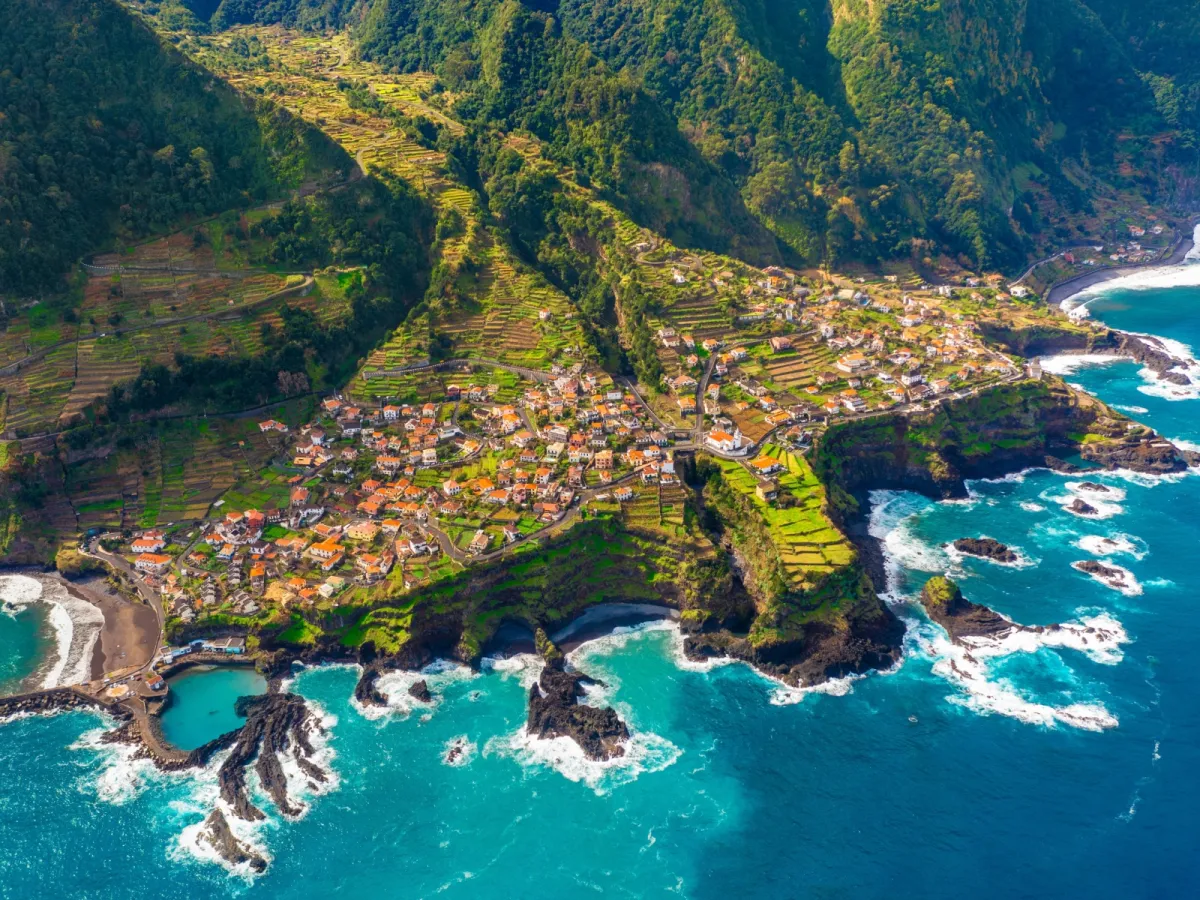 Luftbild einer Stadt auf der Insel Madeira am Rande einer Klippe.