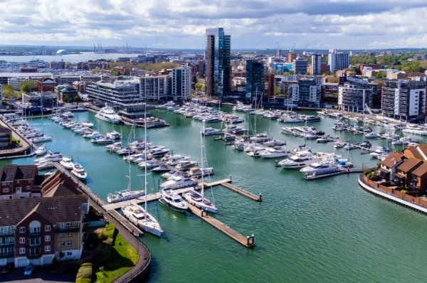 Kleinerer Hafen in Southampton mit Yachten und Skyline im Hintergrund aus der Vogelperspektive.