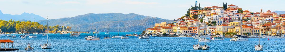 Panorama der Insel Poros und der Stadt an einer Meerenge bei Tag mit einigen Booten.