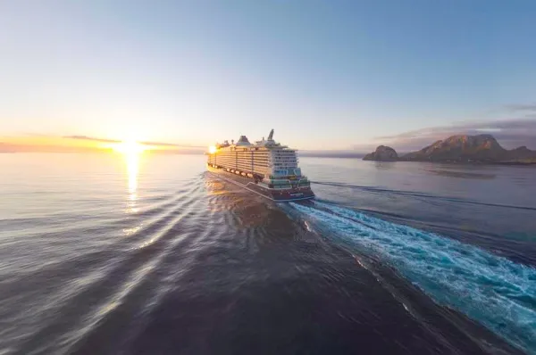 Mit Mein Schiff Flow zu traumhaften Destinationen <i>Mein Schiff Flow</i> Dronenaufnahme während Sonnenaufgang. Das Schiff gleitet im tiefblauen Wasser.