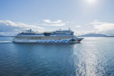 Seitenansicht des AIDAselection Schiffes AIDAsol auf dem Meer. Im Hintergrund ist eine Inselgruppe zu sehen.