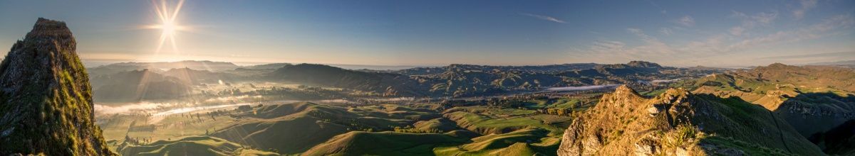 Die Sonne scheint auf die felsige, grüne Landschaft in Napier.