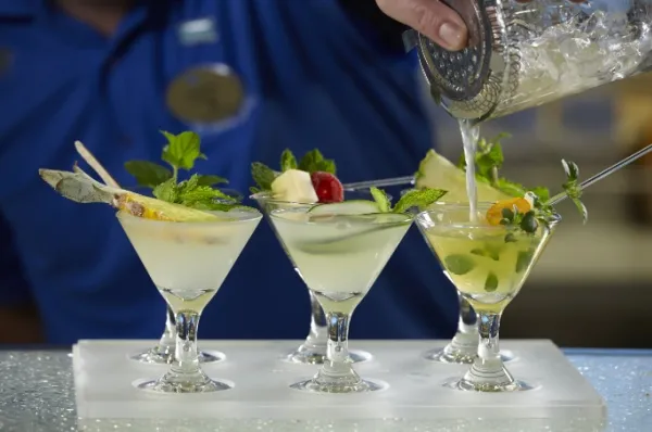 Sechs Mojitos mit ansprechender Dekoration werden vom Barkeeper zubereitet.