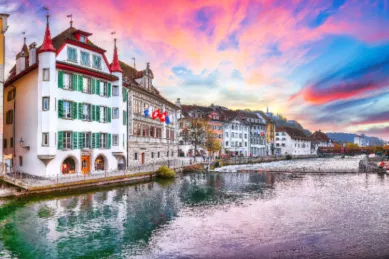 Häuser am Wasser in Luzern Die Wasserkante von Luzerne am Fluss Reuss gesäumt von rustikalen Hausfassaden bei Abendröte.