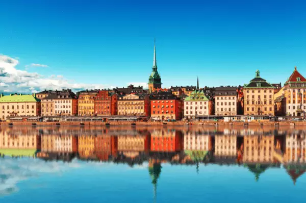 Die Altstadt Gamla Stan im Sommer. Die bunten Häuser der Stockholmer Altstadt spiegeln sich an einem Sommertag im Wasser.