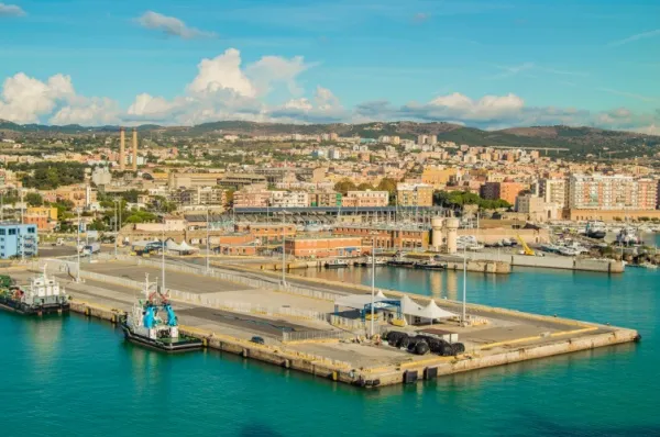 Blick auf Civitavecchia mit vielen Gebäuden und im Hintergrund Berglandschaften unter blauem Himmel.