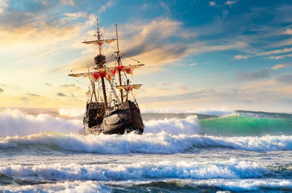 Auf Kielwasser der Geschichte: Erleben Sie den Lockruf vergangener Seefahrerzeiten! Historisches Segelschiff kämpft sich durch hohe Wellen auf dem Meer, Symbol für abenteuerliche Entdeckungsreisen auf historischen Kreuzfahrtrouten.