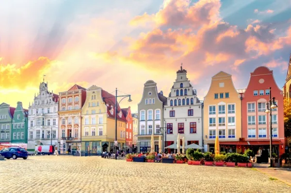 Rostocks historische Altstadt Die historische Altstadt von Rostock bei Sonnenaufgang mitsamt ihren markanten, bunten Altbauten an einem großen gepflasterten Marktplatz.