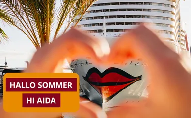 AIDA Kreuzfahrtschiff mit markantem Kussmund, eingerahmt von Händen in Herzform, sommerliche Hafenatmosphäre.