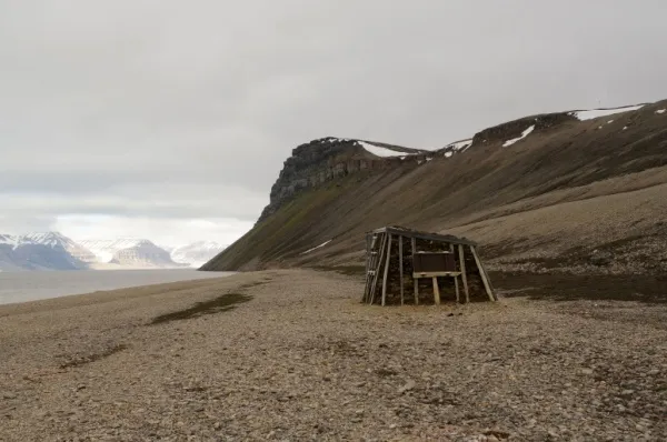 Eine Trapperhütte in Tempelfjorden Eine selbstgebaute Trapperhütte an einem Kiesstrand in Tempelfjorden bei Tag.