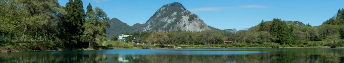 Berg und Wald spiegeln sich auf einem glatten See.