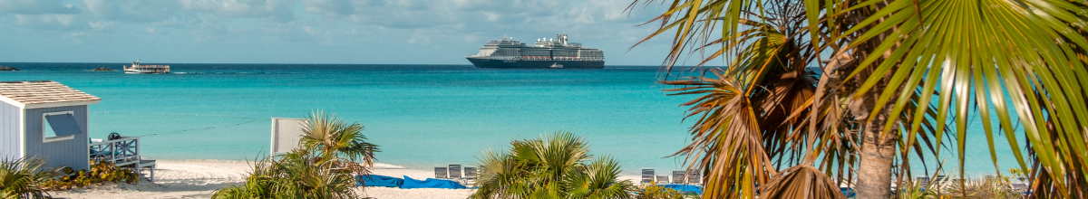 Ein Kreuzfahrtschiff ankert vor einer Karibikinsel.