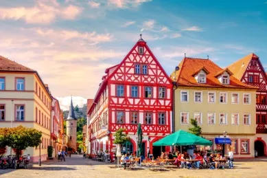 Bunte, sonnenbeschienene Fachwerkhäuser mitsamt lebhaften Cafés in der Karlstädter Innenstadt.