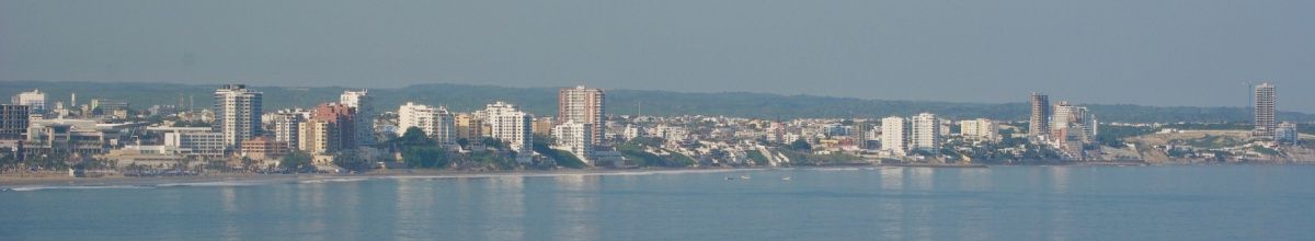 Die Skyline von Manta am Tag, von der Küste aus fotografiert am einem diesigen Tag.